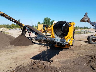 Anaconda TD620 trommel screen stockpiling topsoil, a loader beside it