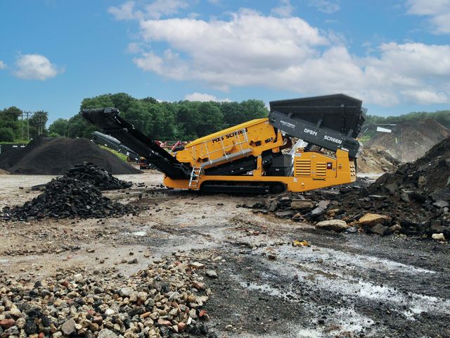 Anaconda DF514 scalping screen on a recycling yard between piles of broken asphalt and concrete