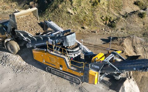 An Anaconda C12R tracked cone crusher fed by a wheel loader on a gravel site