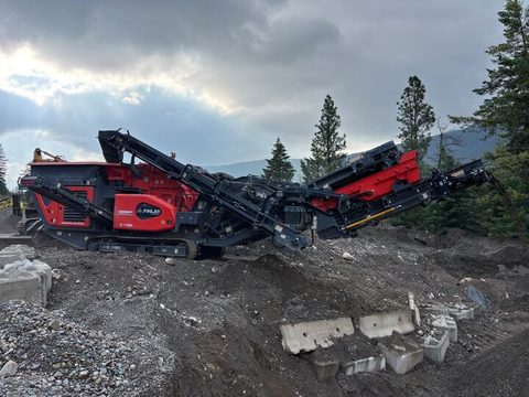 The 2022 Finlay IC-110RS impact crusher on a job site, with broken concrete barriers in front