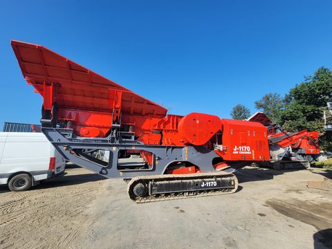 The 2018 Finlay J-1170 jaw crusher parked in a gravel yard, side view